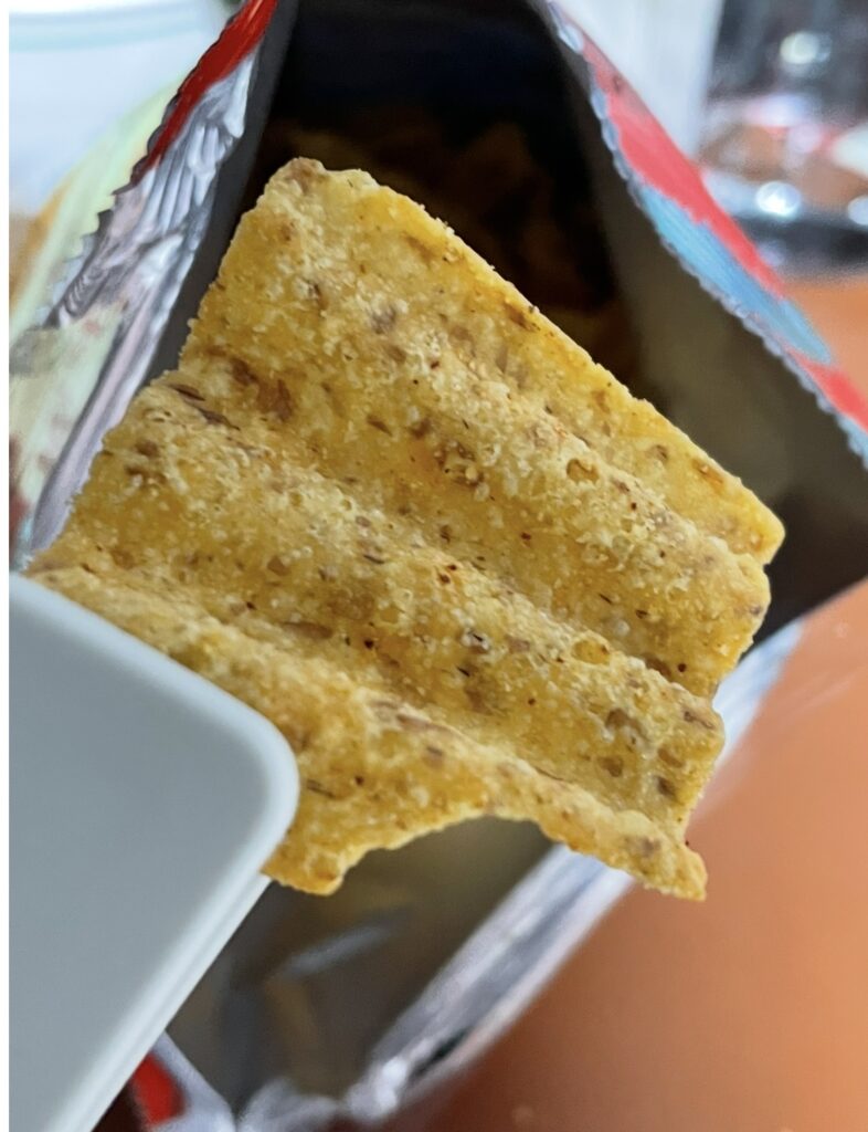 Close-up shot of a Sun Chips Spicy chip, highlighting the seasoning and texture, ideal for a detailed korean snack review