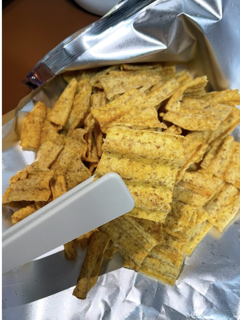 Sun Chips Spicy spread out from the bag, showing the chip color and texture that represent bold korean snack flavors