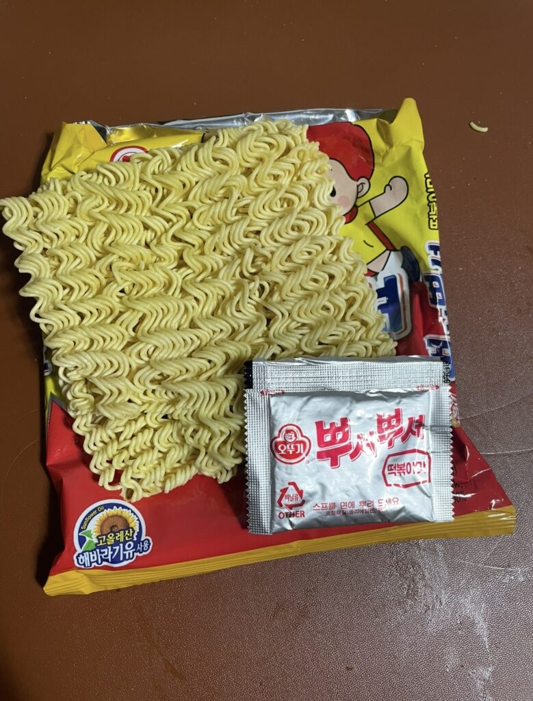 An image showing the noodles and seasoning powder inside the bag. It helps people searching where to buy Korean snack see the actual product components.