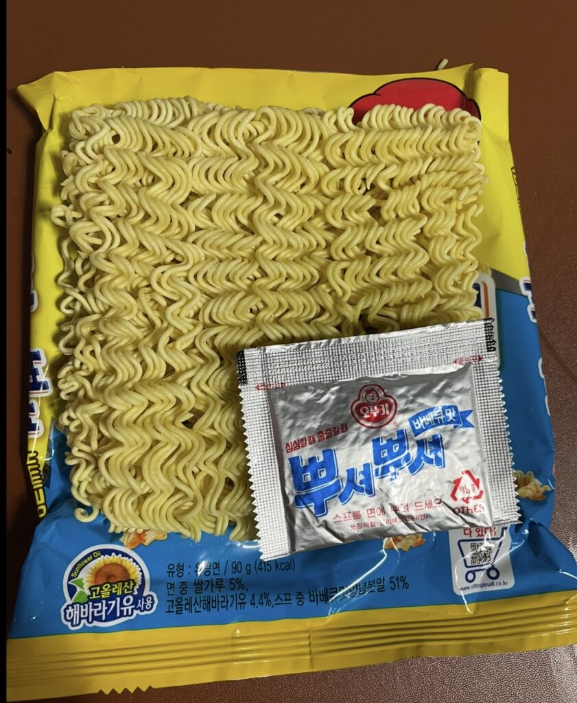 inside the package are flat ramen noodles and a bbq seasoning sachet. a helpful view for those searching where to buy korean snack and curious about the contents.