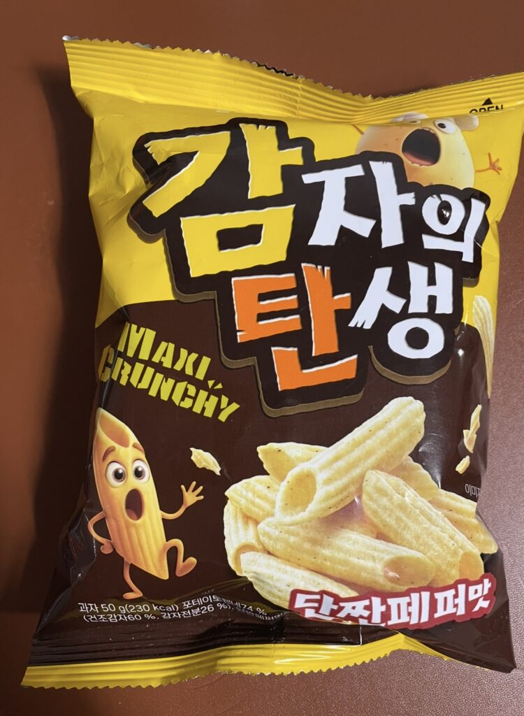 the front package of birth of potato ganjjam pepper showing a bright yellow design and a potato character with a surprised expression, highlighting the product’s unique visual identity.