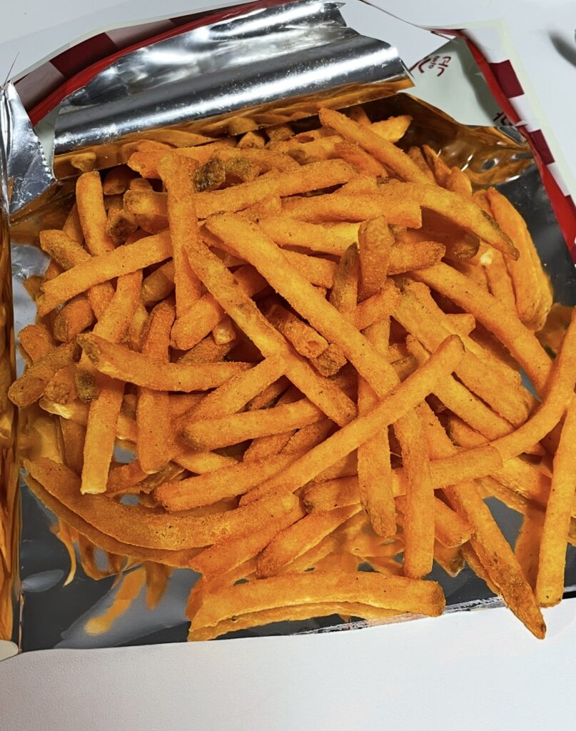 The inside of the foil bag is filled with crispy potato sticks.
The reddish seasoning glows under the light, showing the classic look of a spicy Korean potato snack often introduced on Buy Korean Snacks Online.