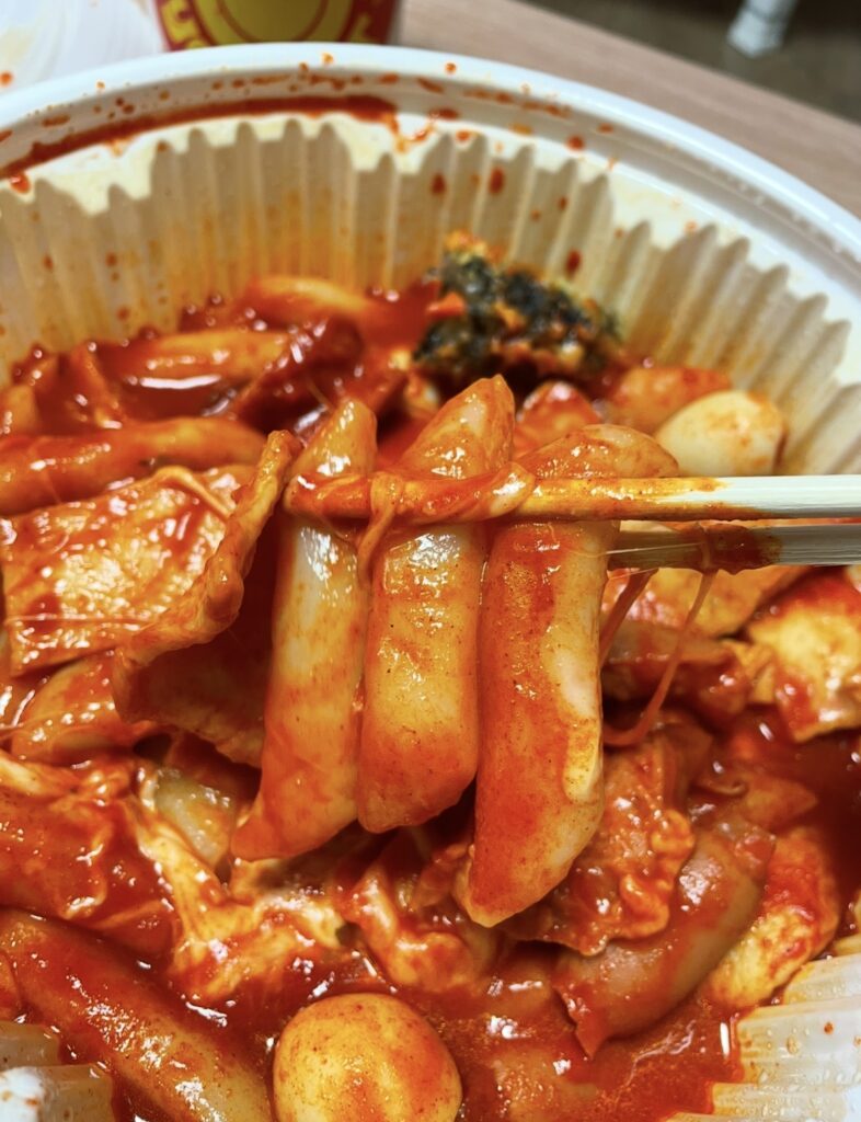 a close-up image of the rice cake pieces and seasoning of dal tokki tteokbokki mild, capturing the real texture and coating suitable for a korean snack review.