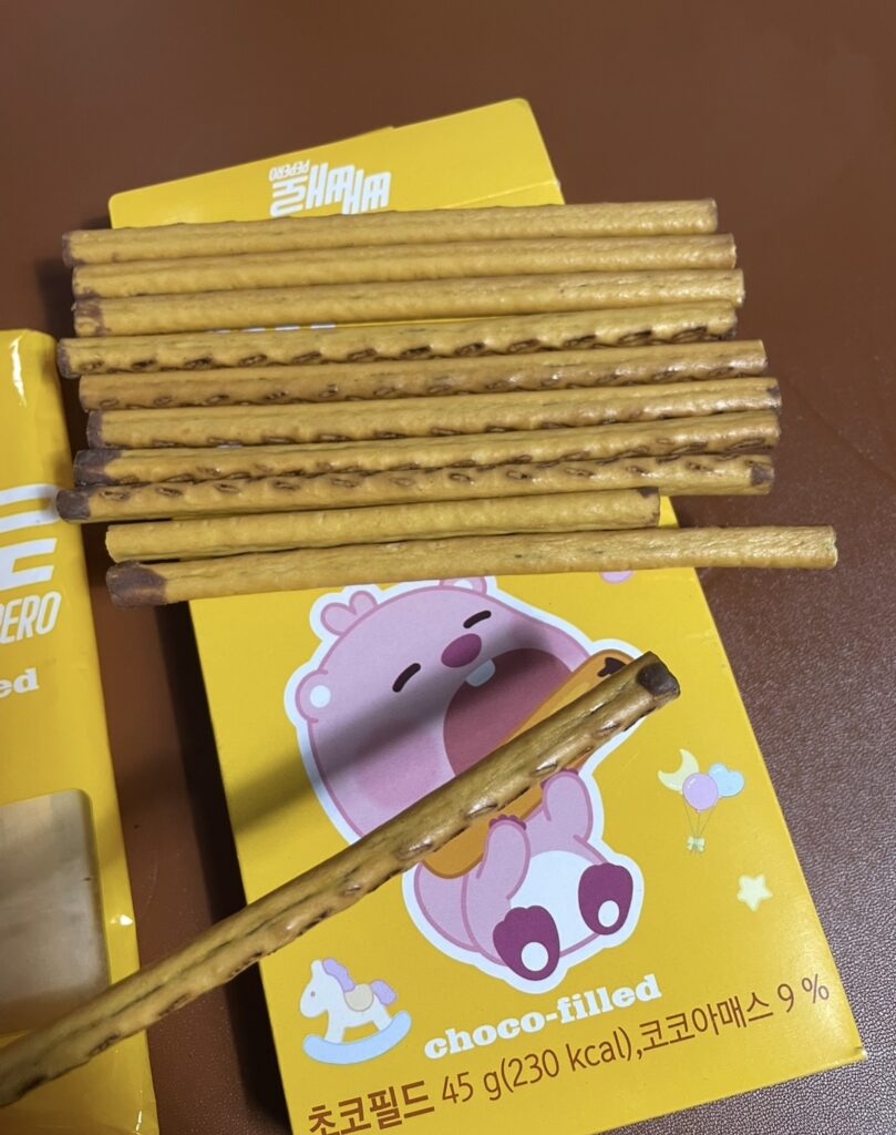 Pepero Choco Filled sticks taken out of the bag and spread out on a table, showing the filled chocolate interior and naturally expressing Korean snack flavors
