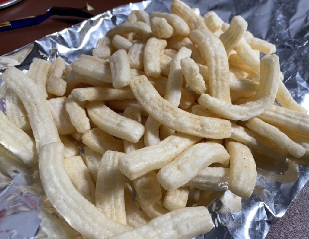 postick snacks are spread on a table. the crisp texture and light potato aroma show korean snack flavors