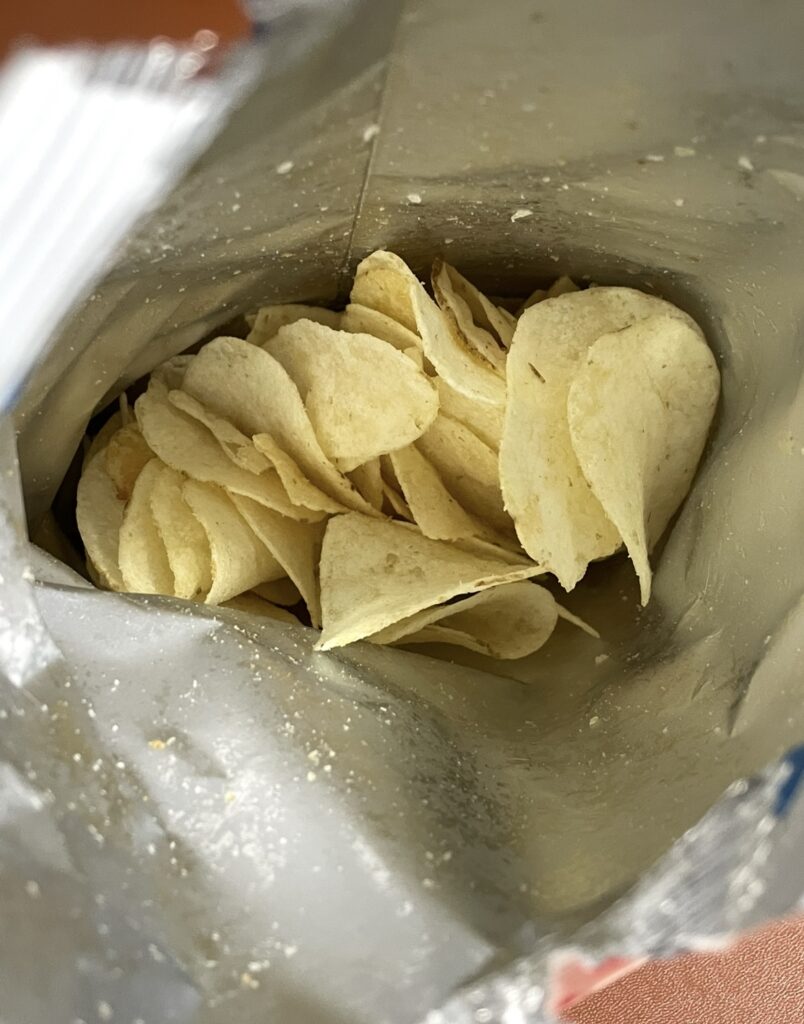 Inside the opened bag, thin and crispy potato chips are neatly packed. It shows the real appearance of a Buy Korean Snacks Online product available on the market
