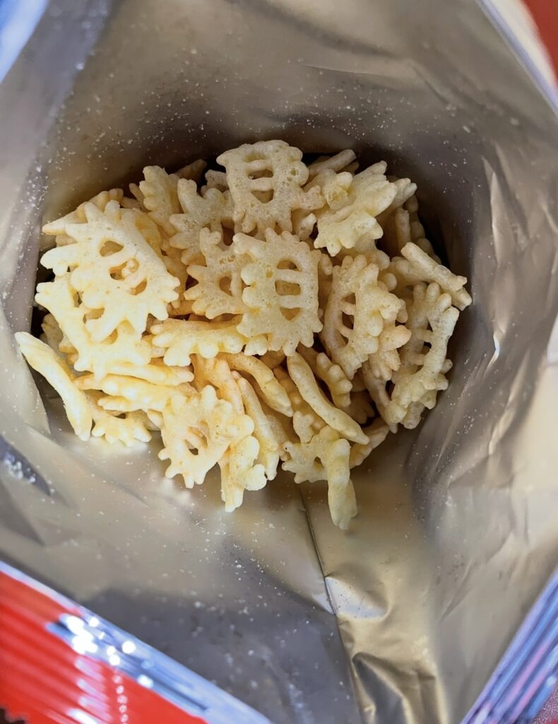 The contents of the Kkotgerang snack, easily purchasable by searching buy korean snacks online. Crab-shaped crackers are visible inside the foil bag