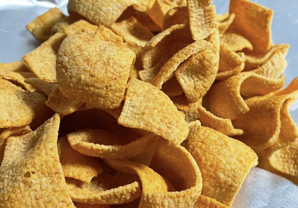 A close-up shot of a single chip that shows its thickness and texture in detail, suitable for a korean snack review